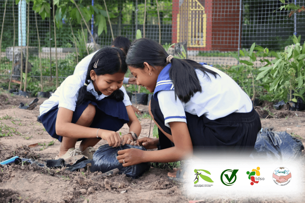 TDSO Teacher and student engaging in gardening activity outdoors.